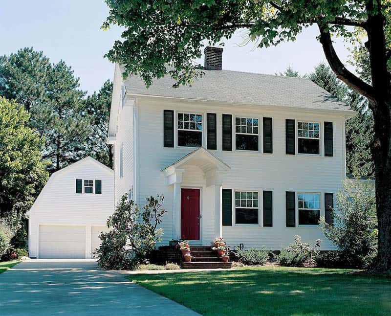 home with white vinyl siding and black shutters